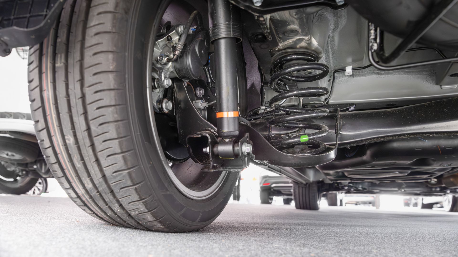 Close-up of car suspension system with wheel, shock absorber, and spring